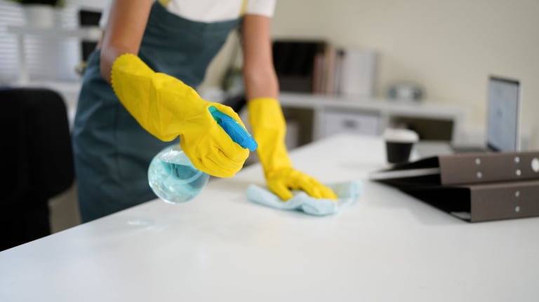 Young woman cleaning table with yellow gloves