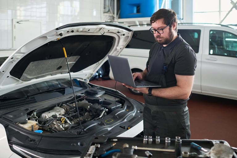 Mechanic using laptop in auto repair shop